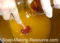 Pouring Citrus Essential Oil Blend into Honey Soap Recipe